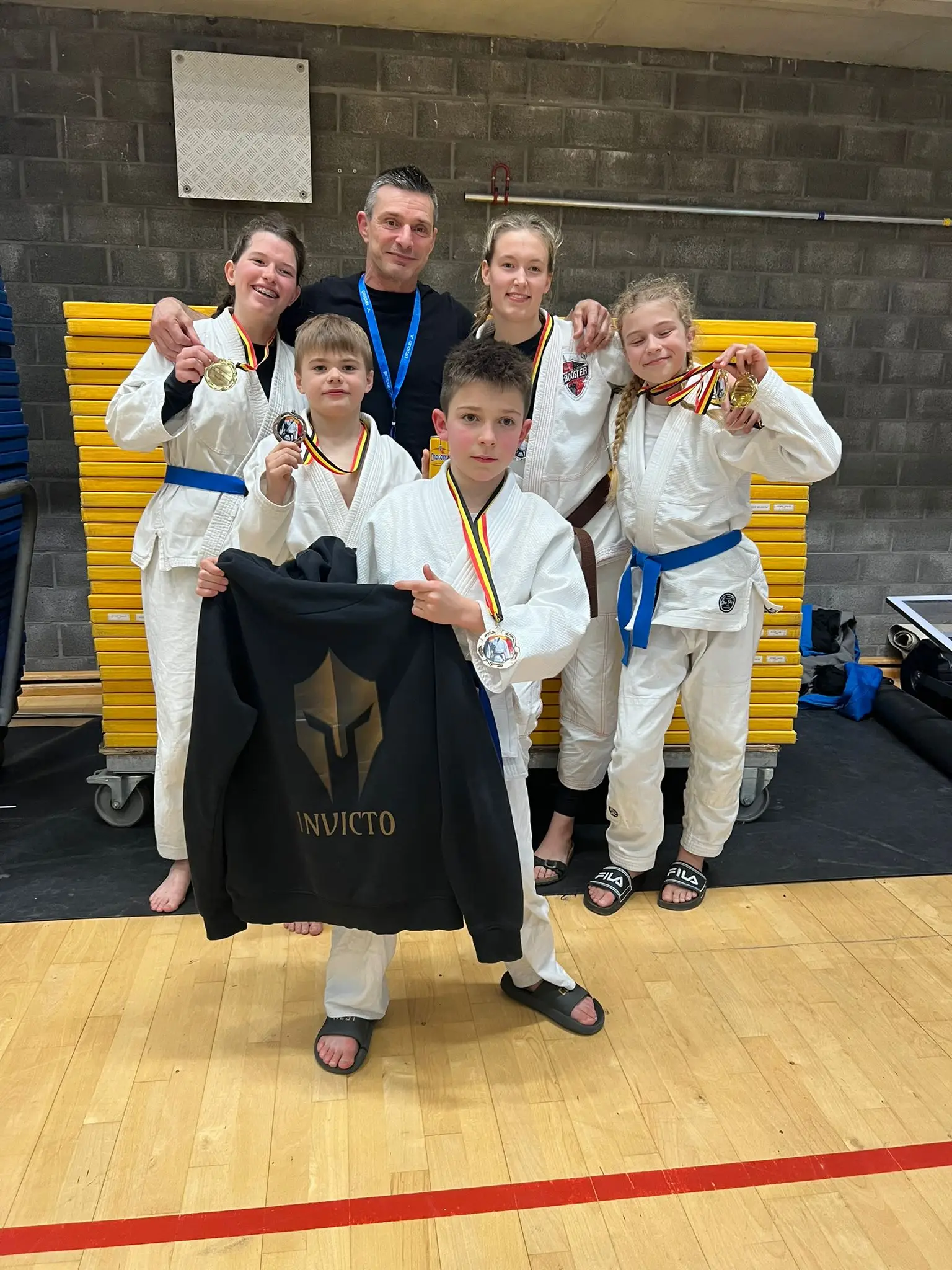 Groepsfoto van coach en enkele atleten van onze club